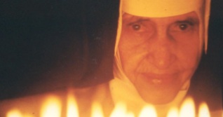 26 de Maio - 1914 – Irmã Dulce, religiosa brasileira - com velas acesas à frente.