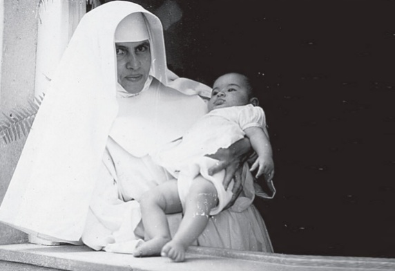26 de Maio - 1914 – Irmã Dulce, religiosa brasileira - jovem, com criança nos braços.